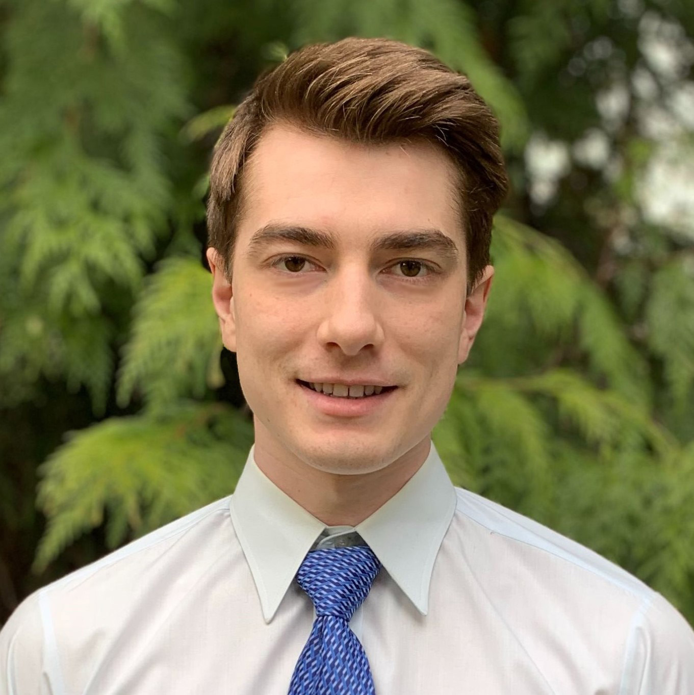 Erik McKelvey in a button up and tie, smiling at the camera.